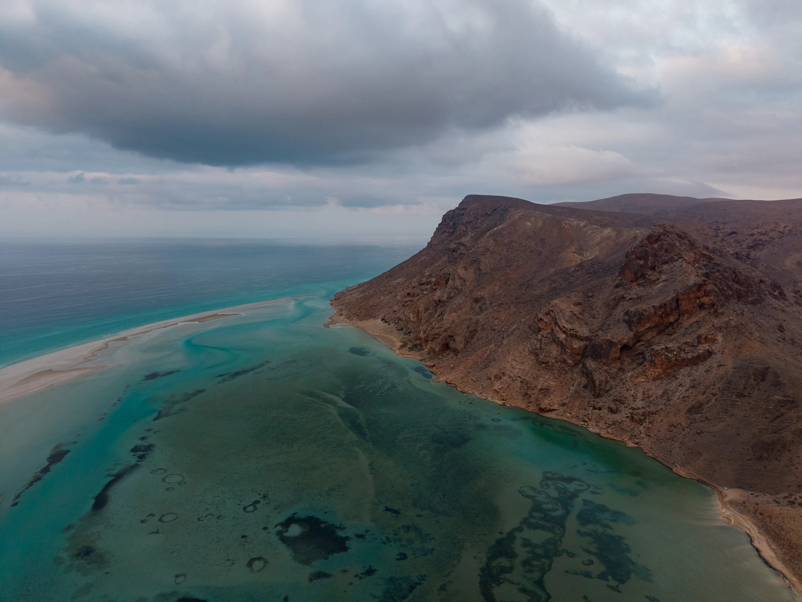 Aerial view of pale dunes meeting the turquoise water of Detwah Lagoon